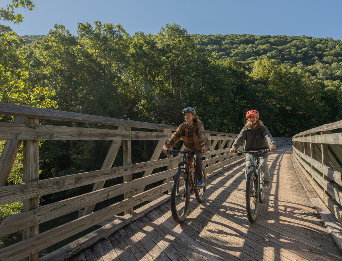 People Biking over a bridge in the greenbrier valley