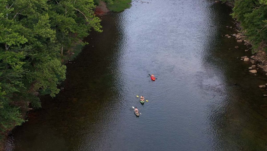 A view of three kayakers on the Greenbrier River.